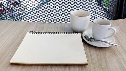 Notebook blank page and coffee cup on wooden table backgrounds