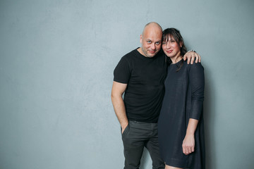 Portrait of a young couple standing against gray background