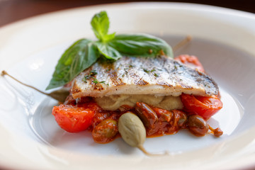 Sea bass fillet with tomato sauce and capers
