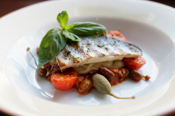 Sea bass fillet with tomato sauce and capers