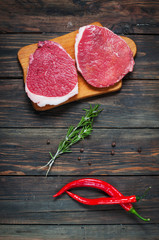 Fresh raw beef steak and chilli pepper on wood