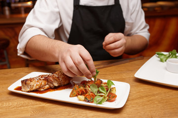 Chef is decorating chicken teriyaki dish