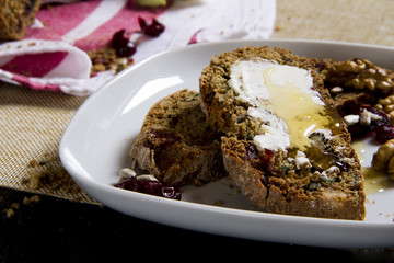 a slice of homemade sweet bread with butter and honey topping on a white plate