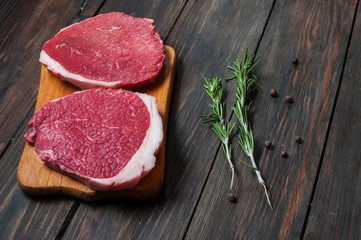 Fresh raw beef steak and chilli pepper on wood