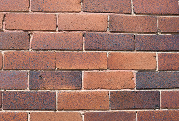 Imperfect, aged, red brick exterior wall
