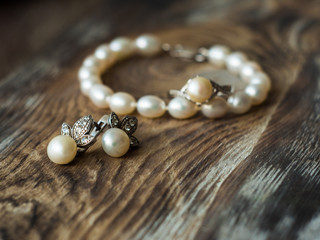 Beautiful pearl bracelet and earrings on elegant background, close up. shallow depth of field