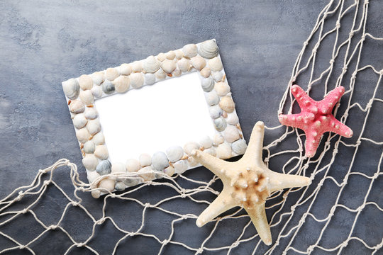 Frame of sea shells with starfish on wooden table