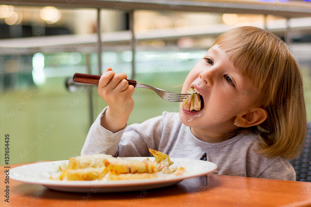 Wall mural Little girl eating pancake