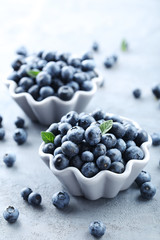 Ripe and tasty blueberries on grey wooden table