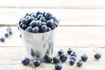 Ripe and tasty blueberries on grey wooden table