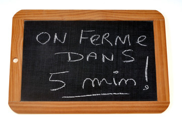 Obraz premium On ferme dans cinq minutes écrit sur une ardoise 