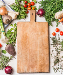 Cutting board and fresh organic vegetables for tasty vegan or vegetarian cooking, top view, frame,...
