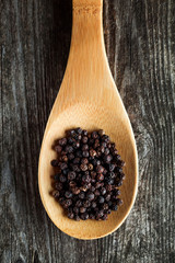 Black pepper spice peppercorn on wooden background