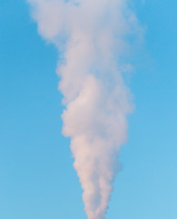 white industrial smoke from the chimney on a blue sky