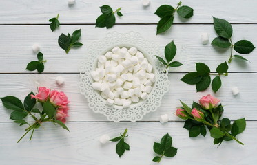 marshmallows and a roses on a white wooden background.flat lay. women's day, 8 march, 8 марта
