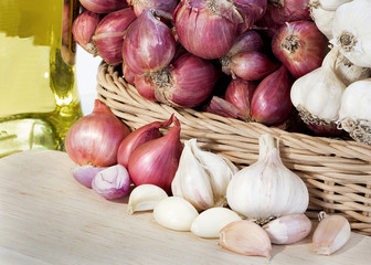 garlic, garlic cloves,onion and cooking oil on wooden background.