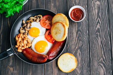 Breakfast tomatoes, sausages, beans, mushrooms, eggs,toast and herbs top view