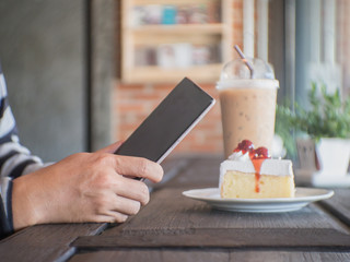 Man take the photo in cafe with cake and ice coffee.