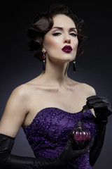 Young beautiful brunette woman posing with perfume bottle