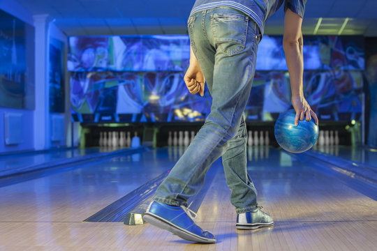 the man holding the bowling ball in the background of the playing field