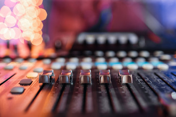 od adjusters and red buttons of a mixing console. It is used for audio signals modifications to...