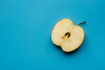 Minimal photo. Sliced apple with seed on blue background. Top view