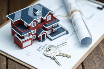 Villa house model, key and drawing on retro desktop (real estate sale concept)