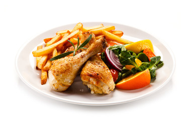 Grilled chicken legs with chips and vegetables 