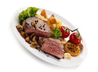 Steaks, baked potatoes and vegetable salad 