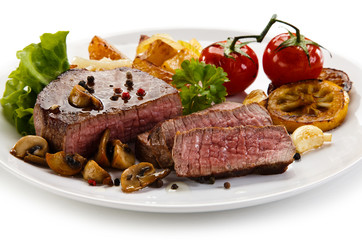 Steaks, baked potatoes and vegetable salad 