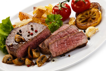 Steaks, baked potatoes and vegetable salad 