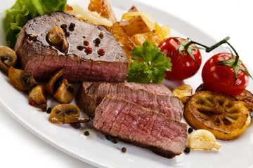 Steaks, baked potatoes and vegetable salad 