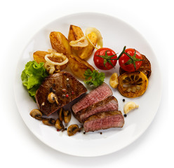 Steaks, baked potatoes and vegetable salad 