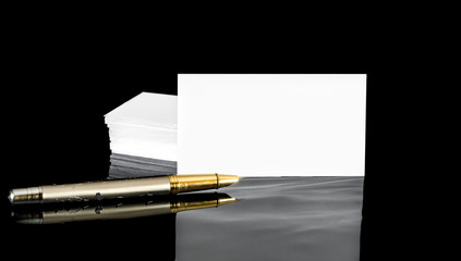 Business cards with pen on black reflective background. Business concept.