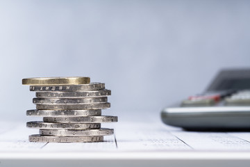 Taschenrechner und ein Stapel Euromünzen auf einer Tabelle, Hintergrund