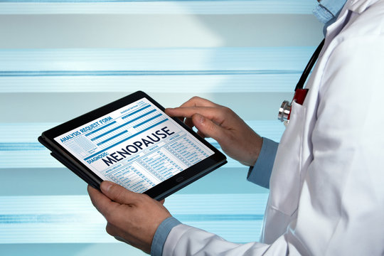 Gynecologist Holding Tablet With A Menopause Diagnosis In Digital Medical Report / Doctor With Medical Record Digital On The Tablet With Text Menopause In Diagnostic