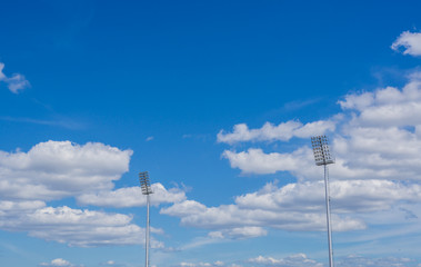 high pole Spotlight Stadium lights with blue sky background.