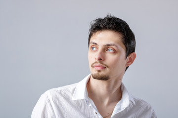 Fototapeta premium portrait of handsome young man with dark hair in white shirt on 