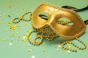 Golden Carnival masks with beads on a green background.