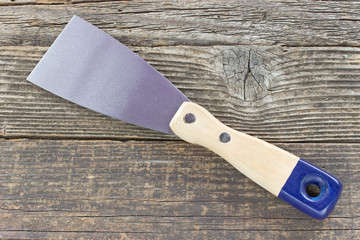 Spatula scraper putty tool on wooden background