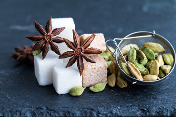 Sugar cubes and spices - anise, cardamom - on slate - ingredients for hot aromatic drinks