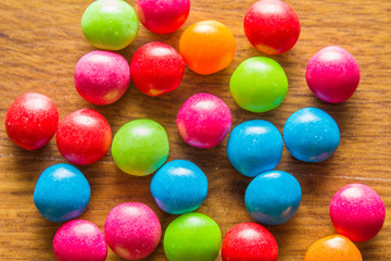 Pile of colorful candy drops on wooden background
