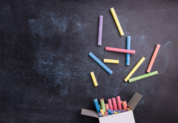 Top view of colorful chalk on blackboard background. 