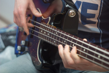 young man plays bass guitar