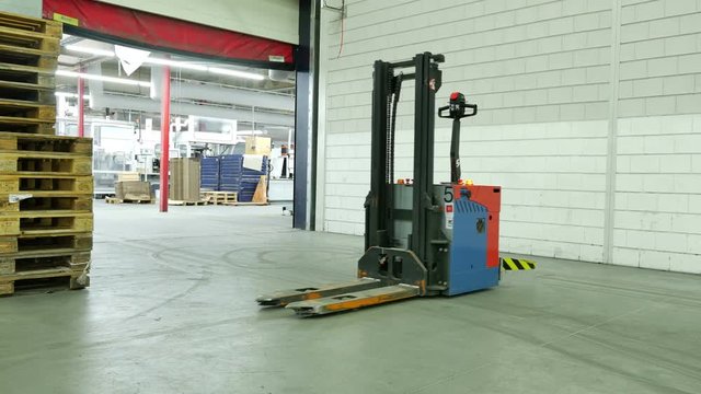 Forked Automatic Guided Vehicles (AGV) pallet truck, unmanned driving through factory hall