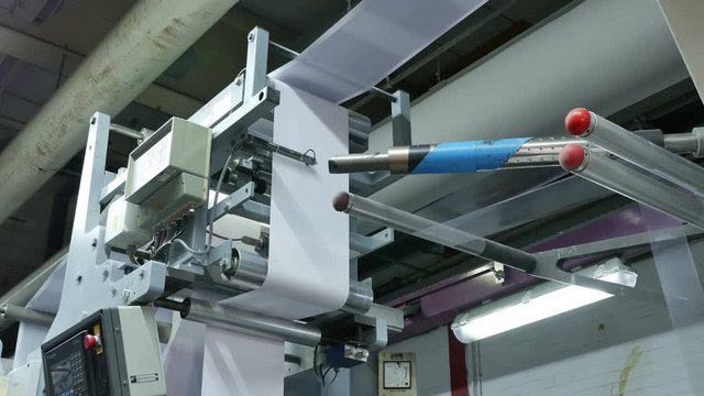 Envelope paper roll being printed in a big factory, assembly line