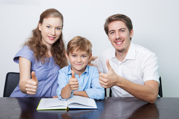 Happy Mom, Dad and Son Reading Book With Thumbs Up