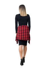 Back view of elegant young woman in black dress and stiletto shoes walking away. Full body length isolated over white studio background. 