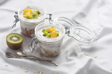 Healthy breakfast of muesli with yogurt and fruit in a glass jar in bed. Healthy foods for breakfast