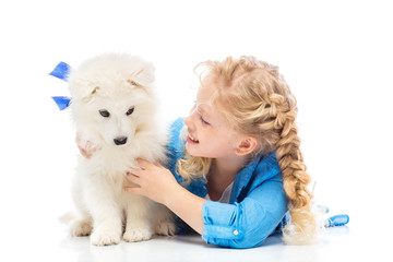 Little girl with a samoyed puppy